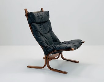 May include: A black leather lounge chair with a wooden frame. The chair has a curved back and a padded seat.