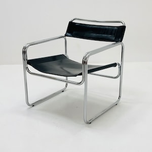 May include: A black leather chair with a chrome frame. The chair has a simple, modern design.