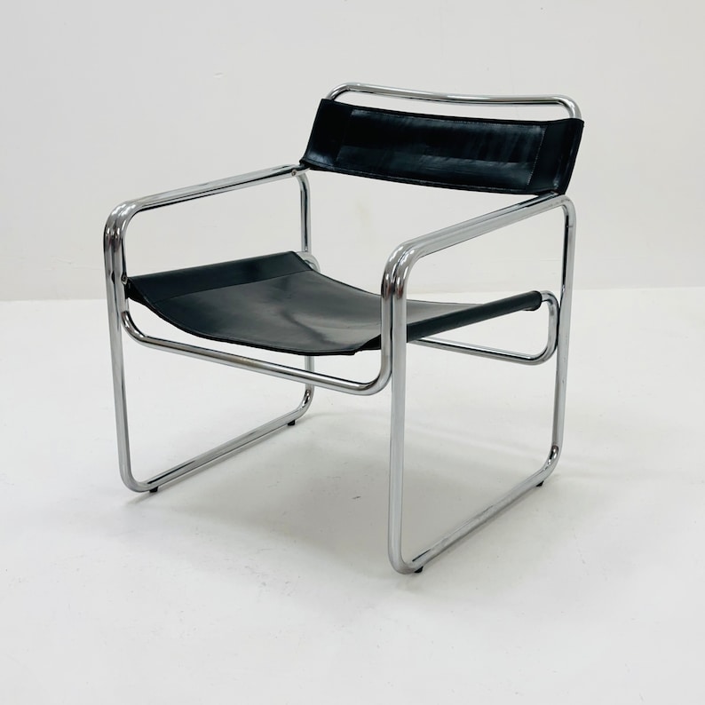 May include: A black leather chair with a chrome frame. The chair has a simple, modern design.