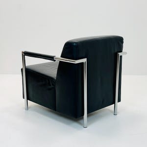May include: A black leather armchair with a chrome frame. The chair has a simple, modern design.