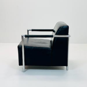 May include: A black leather armchair with a chrome frame. The chair has a simple, modern design.