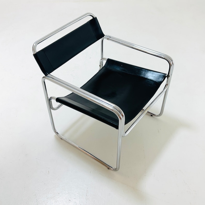 May include: A black leather chair with a chrome frame. The chair has a simple, modern design.