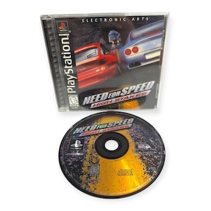 May include: A PlayStation video game case and disc for Need for Speed High Stakes. The case features a red and silver car on the cover with the Electronic Arts logo. The circular game disc has a yellow and black asphalt road graphic design.