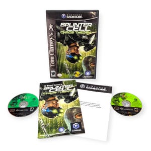 Op de afbeelding: Een complete Nintendo GameCube-gameset voor "Tom Clancy's Splinter Cell: Chaos Theory". De set bevat de gamecase, disc, handleiding en een kleine insert. De gamecase bevat een donkere afbeelding van een gemaskerd personage.
