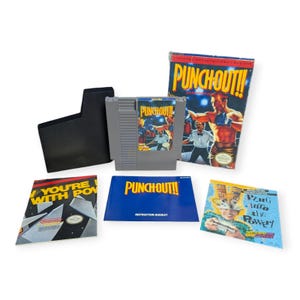 May include: A complete Nintendo Entertainment System (NES) video game set for Punch-Out!!, featuring the game cartridge, box, instruction booklet, and other inserts. The box art depicts a boxer in action. The game cartridge is gray.