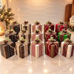 May include: A collection of twelve square wooden blocks decorated as gifts, featuring various patterns including plaid, stripes, and solid colors. Each block is topped with a small pinecone and green sprig tied with twine.