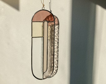 Modern stained glass suncatcher in subdued colors, window decoration, glass wall hanging