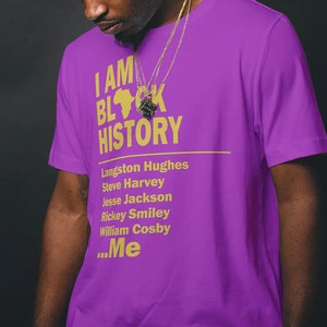 Puede incluir: Camiseta morada con el texto "I AM BLACK HISTORY" en letras doradas. La camiseta también presenta una lista de nombres en letras doradas, incluyendo Langston Hughes, Steve Harvey, Jesse Jackson, Rickey Smiley, William Cosby y "...Me".
