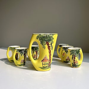 May include: A set of five yellow ceramic cups with tropical designs. The cups are decorated with palm trees, huts, and other tropical motifs. The cups are all different sizes and shapes.