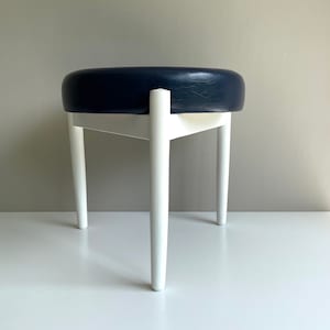 Vintage stool. Three-legged. Wood. Hugo Frandsen style. Faux leather. Midnight blue. White. Scandinavian. 1960s