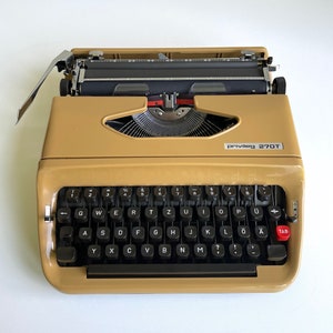 Vintage typewriter. Privileg. 270T. Plastic. Ochre yellow. Quelle. With case. 1960s