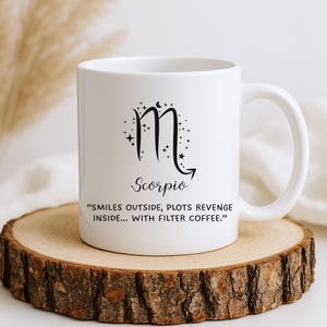 May include: White ceramic mug featuring the Scorpio zodiac symbol and the word "Scorpio" in black script. The mug also includes the quote: "smiles outside, plots revenge inside... with filter coffee."