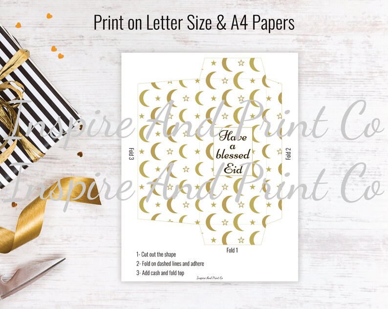 May include: Printable template for a gold and white envelope with a crescent moon and star pattern. The envelope has instructions to fold and add cash. The text on the envelope reads "Have a blessed Eid".