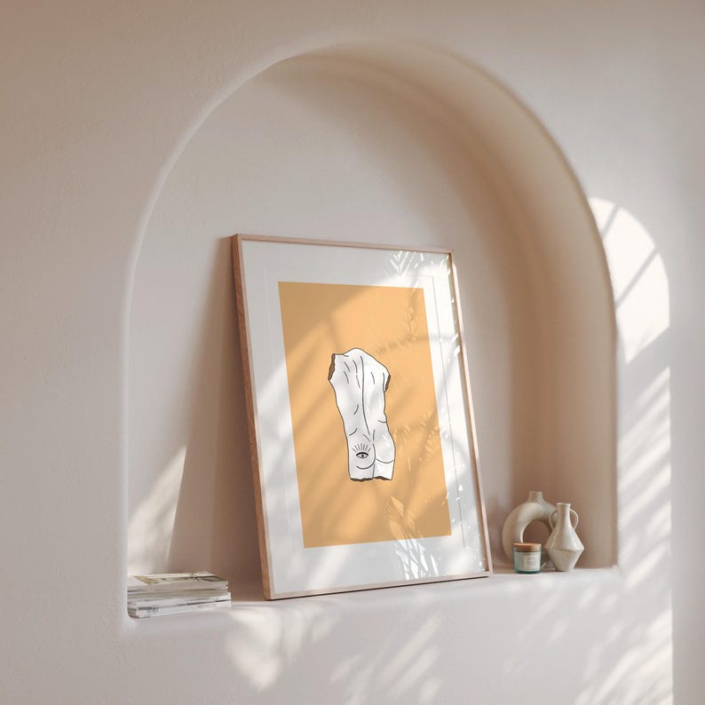 Peut inclure: Une impression encadr&eacute;e avec un dessin au trait minimaliste d'un torse humain avec un &oelig;il sur le dos. Le fond est de couleur jaune clair.