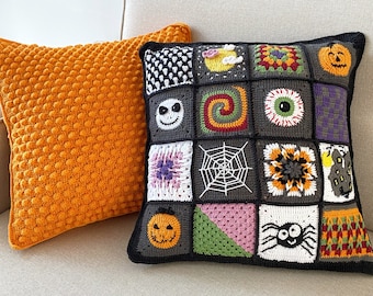 May include: Two decorative throw pillows, one orange and one black with a patchwork design featuring various Halloween-themed motifs, including pumpkins, spiders, and a skull. The pillows are on a light beige couch.