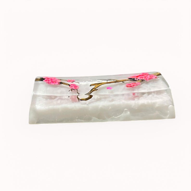 Peut inclure: Un plat rectangulaire blanc avec un motif de cerisier rose et or. Le plat est en verre et a une forme l&eacute;g&egrave;rement incurv&eacute;e.