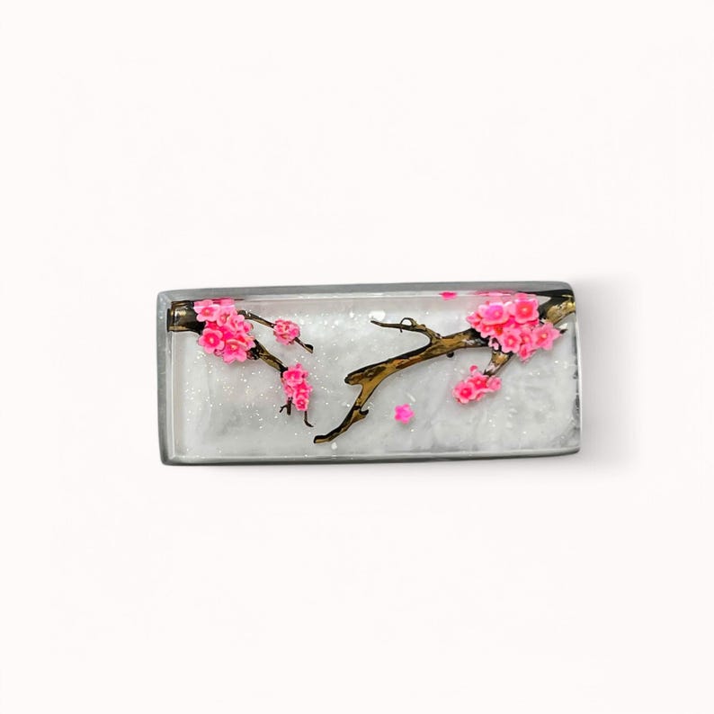 Peut inclure: Un porte-cl&eacute;s rectangulaire en r&eacute;sine avec un fond blanc et une branche dor&eacute;e avec des fleurs de cerisier roses.