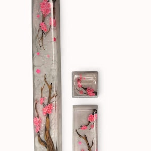 Peut inclure: Un ensemble de trois touches de clavier avec un fond blanc et un motif d&eacute;licat de fleurs de cerisier roses. Les touches sont en r&eacute;sine transparente et ont une finition brillante.