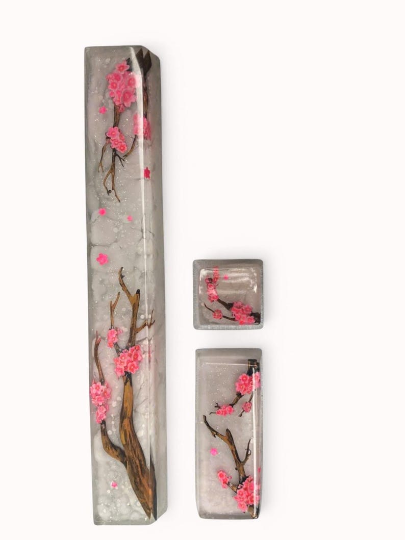 Peut inclure: Un ensemble de trois touches de clavier avec un fond blanc et un motif d&eacute;licat de fleurs de cerisier roses. Les touches sont en r&eacute;sine transparente et ont une finition brillante.