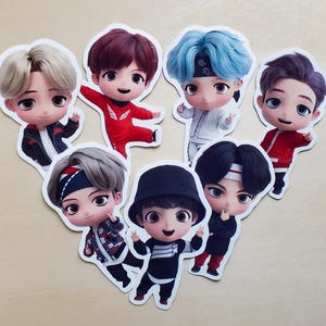 May include: Seven cartoon stickers depicting male figures with diverse hairstyles and clothing. The stickers, with white borders, are arranged in a heart shape. The figures are in various poses, some waving or making peace signs. Each figure has a unique outfit.