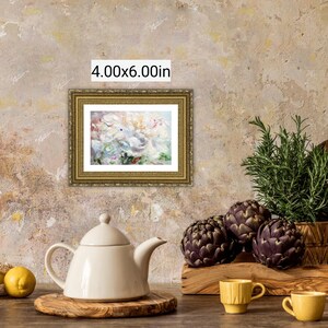 May include: A still life featuring a framed 4.00x6.00in painting, a white teapot, lemons, artichokes, and rosemary. The painting has a gold frame. Two yellow cups and a wooden cutting board are also present.