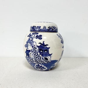 May include: A white ceramic jar with a blue and white floral design. The jar has a lid and is decorated with a traditional Chinese pattern.