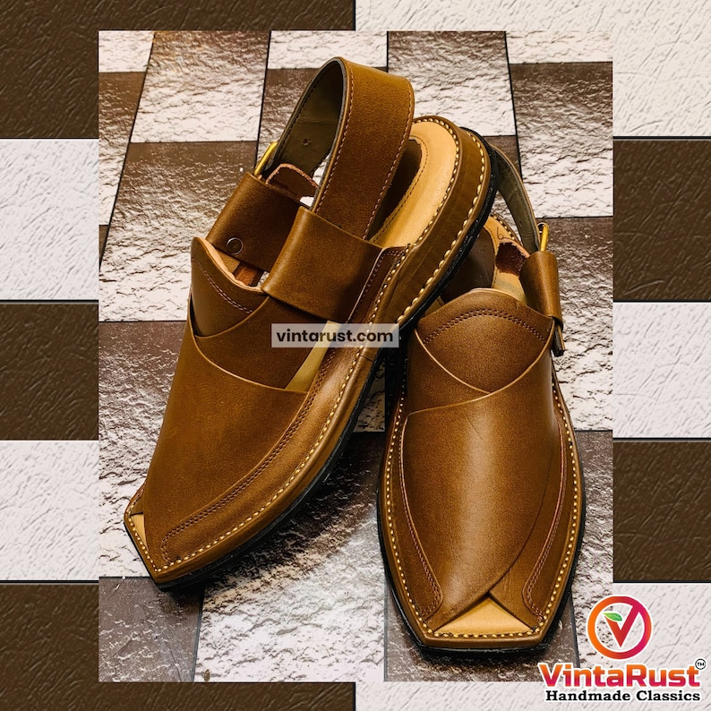 K&ouml;nnte beinhalten: Ein Paar braune Ledersandalen mit spitzer Zehenpartie und einem Riemen &uuml;ber dem Fu&szlig;r&uuml;cken. Die Sandalen haben ein gen&auml;htes Design und eine schwarze Sohle.