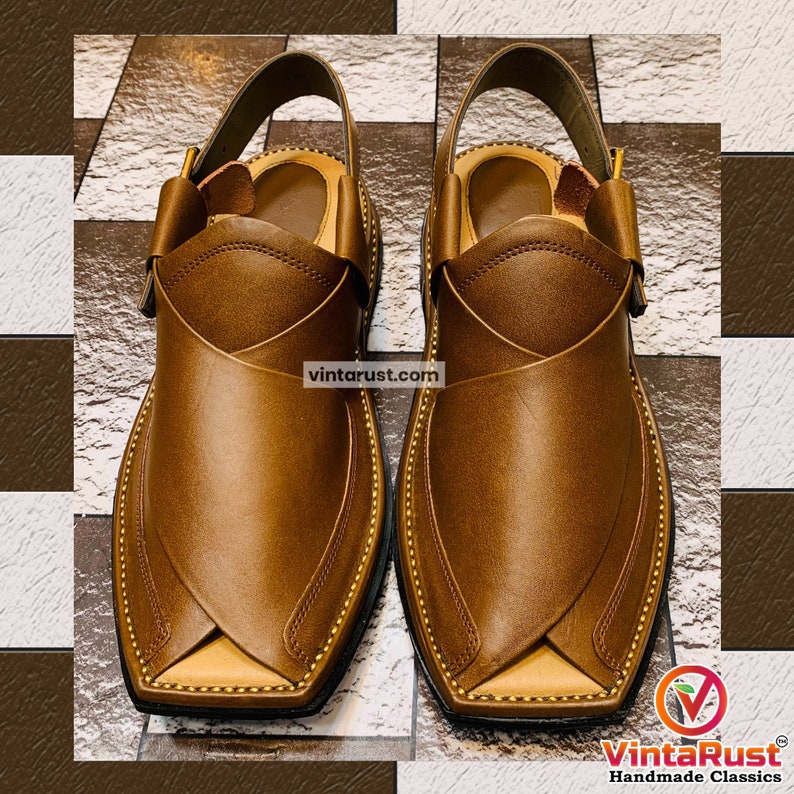 K&ouml;nnte beinhalten: Ein Paar braune Ledersandalen mit spitzer Zehenpartie und einem Riemen &uuml;ber dem Fu&szlig;r&uuml;cken. Die Sandalen haben ein dekoratives Steppdetail an den R&auml;ndern.