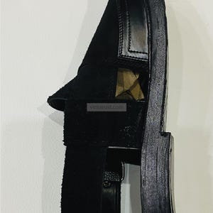 May include: Black leather sandal with a suede strap. The sandal features a thick sole and a minimalist design. The image includes the text "vintarust.com" and the VintaRust Handmade Classics logo.