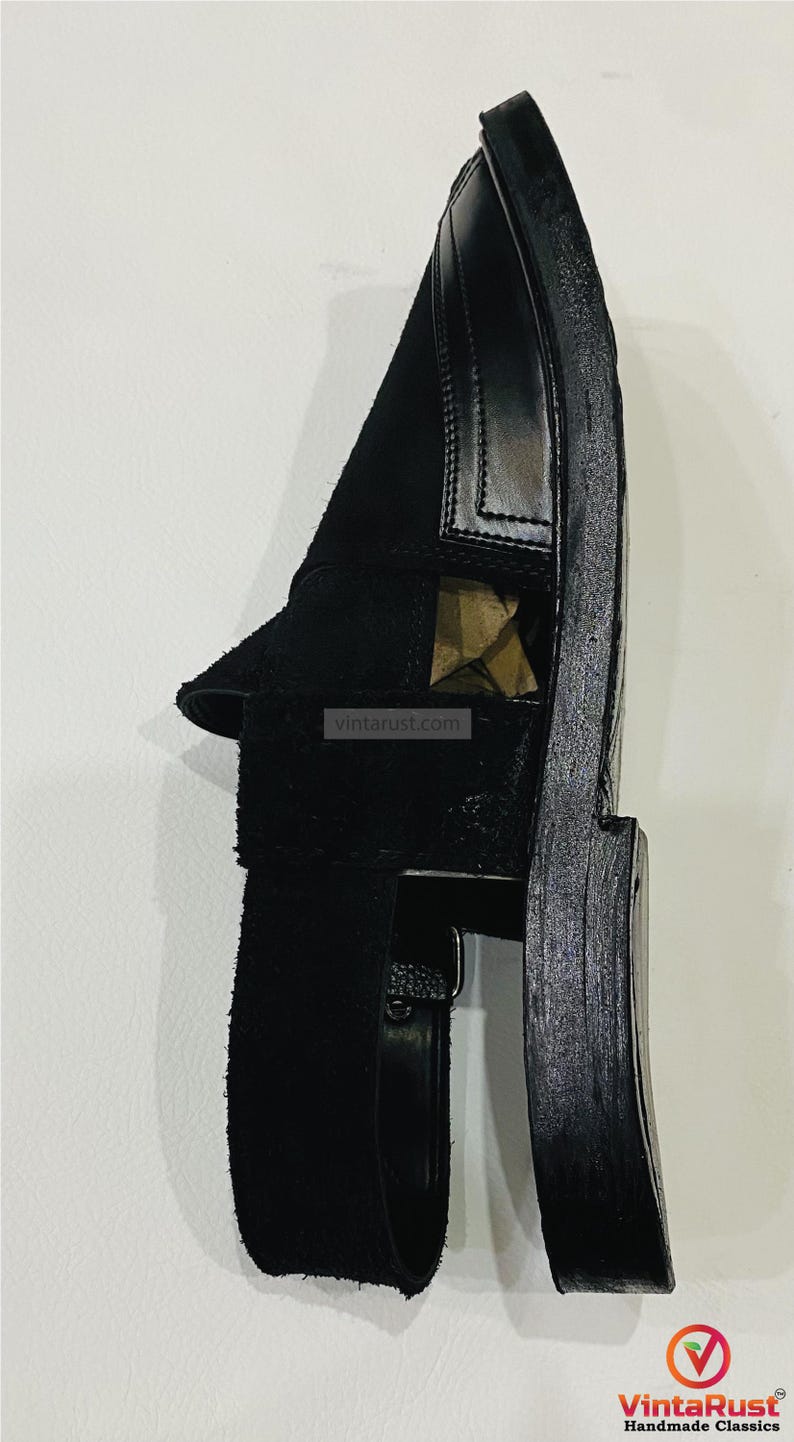 May include: Black leather sandal with a suede strap. The sandal features a thick sole and a minimalist design. The image includes the text "vintarust.com" and the VintaRust Handmade Classics logo.