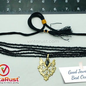 May include: Black beaded choker necklace with a gold-toned pendant. The necklace features multiple strands of small, round beads and a decorative pendant with a black stone. The text "Good Jewelry for Best Occasion" is visible.