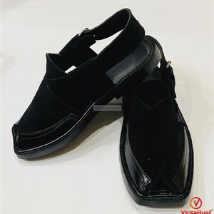 May include: A pair of black leather sandals with a closed-toe design. The sandals feature a strap that goes around the ankle and a buckle closure. The upper part of the sandal is made of suede, and the sole is made of leather.