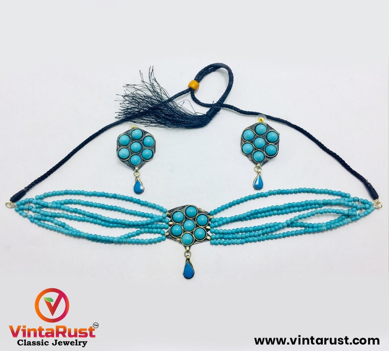 May include: A turquoise blue choker necklace with a multi-strand design and a pendant featuring a turquoise stone cluster. Matching earrings with turquoise stone clusters are also included.