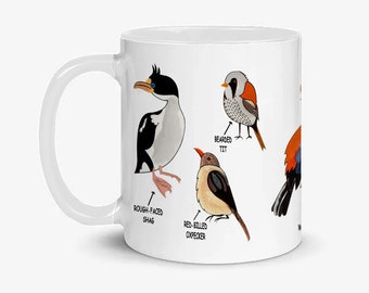 May include: White ceramic mug with a colorful illustration of five different birds. The birds are labeled "Rough-faced Shag", "Bearded Tit", "Red-billed Oxpecker", and two unlabeled birds.