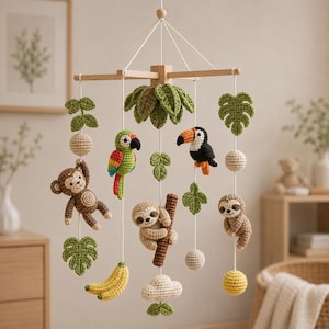 May include: A hanging nursery mobile featuring crocheted figures of a brown monkey, a green parrot, a black and orange toucan, and a light brown sloth. The mobile includes crocheted green leaves, yellow bananas, and white spheres suspended from a wooden frame.