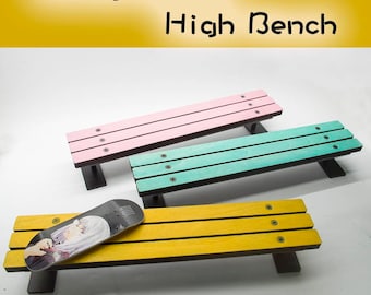 May include: Three colorful benches with black legs. The benches are pink, teal, and yellow. A skateboard with a graphic is on the yellow bench. The text "Guaiguaichai High Bench" is at the top.