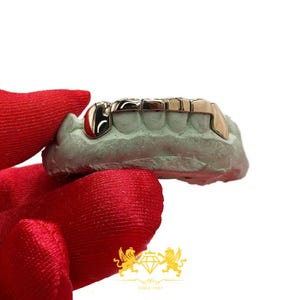 Rose gold custom 6-tooth grillz set with solid canine caps mounted on green dental plaster cast