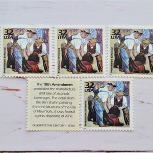 May include: Four vintage US postage stamps depicting a painting of three men pouring wine from a barrel. The stamps are from 1920 and commemorate the 18th Amendment, which prohibited the manufacture and sale of alcoholic beverages. The text "Prohibition Enforced" is printed on each stamp.