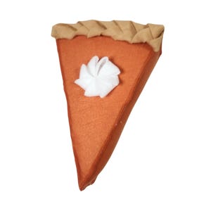 May include: A felt pumpkin pie slice with a white whipped cream topping. The pie crust is brown and the filling is orange.