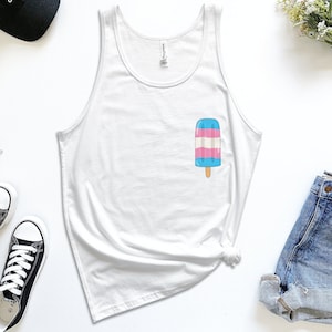 May include: White tank top with a blue, pink, and white popsicle graphic. The popsicle is a representation of the transgender pride flag.