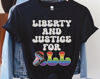 May include: Black t-shirt with the text "LIBERTY AND JUSTICE FOR ALL" in white, with a rainbow and brown and black stripes in the "ALL" text.