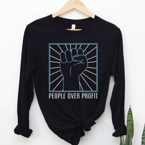 May include: Black long-sleeve shirt with a graphic of a raised fist in a circle with radiating lines and the text "PEOPLE OVER PROFIT" below.