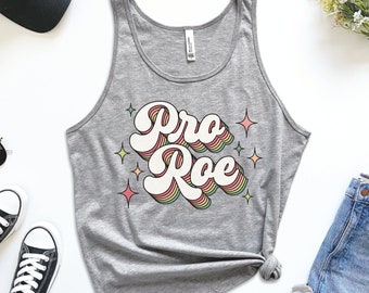 May include: A gray tank top with a retro-style graphic that says "Pro Roe" in rainbow colors. The graphic is surrounded by small stars.