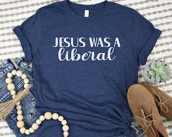 May include: A navy blue t-shirt with the text "JESUS WAS A liberal" in white lettering.