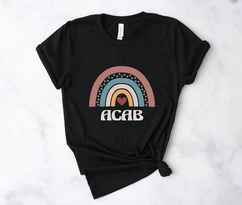 May include: Black t-shirt with a rainbow design and the text "ACAB" in white.