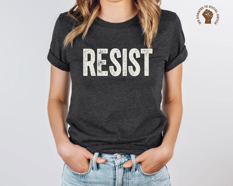 A dark grey heather unisex crew neck short sleeve Bella+Canvas t-shirt that says "RESIST" in distressed white tall block text