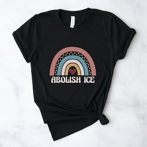 May include: Black t-shirt with a rainbow graphic and the text "Abolish ICE" in white letters.