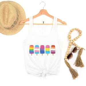 Pu&ograve; includere: Canotta bianca con una grafica di cinque ghiaccioli arcobaleno. I ghiaccioli sono disposti in fila e ognuno ha uno schema di colori diverso che rappresenta diverse bandiere pride.