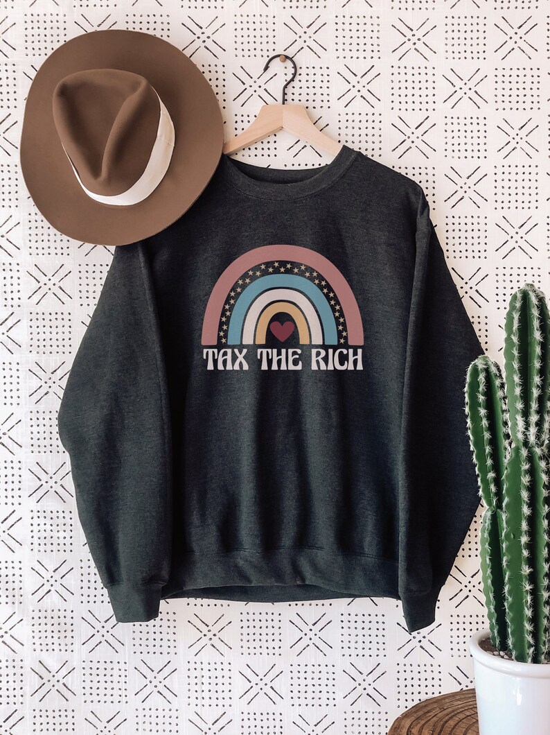 May include: A dark gray sweatshirt with a rainbow graphic and the text "Tax the Rich" in white. The rainbow is made up of pink, blue, yellow, and orange stripes with a red heart in the center.
