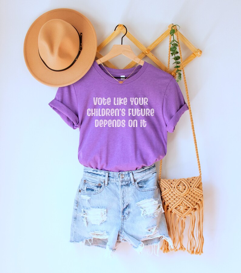A heather team (medium) purple unisex crew neck short sleeve Bella Canvas t-shirt that says "vote like your children's future depends on it" in white chalkboard font